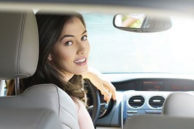 a woman looking back from the driver seat of a vehicle