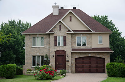 a large brick building with grass in front of a house